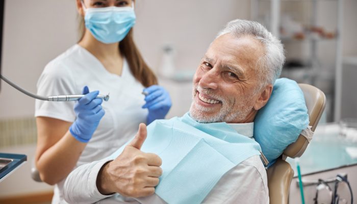 Joyful,Senior,Citizen,Sitting,In,A,Dental,Chair,Showing,Thumbs